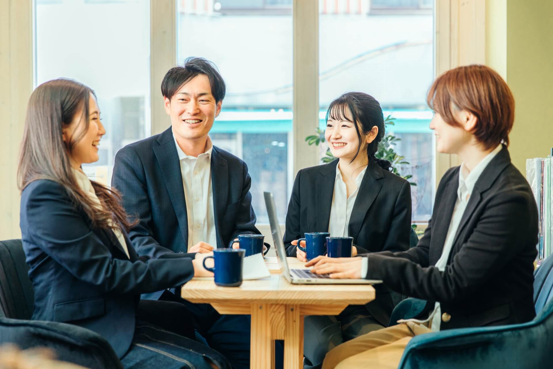 会議室で議論する四人のビジネスパーソン