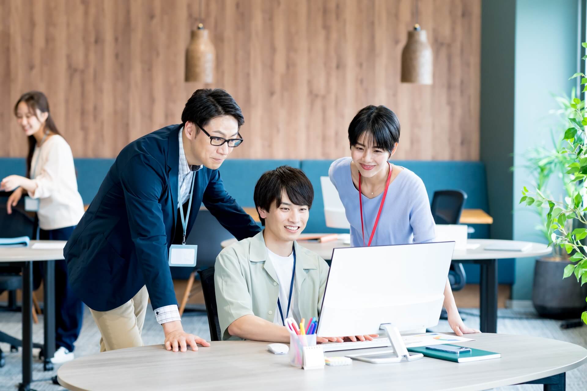 オフィスで協力して働く三人の同僚